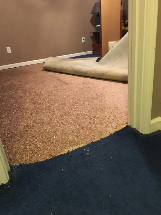 Carpet pad removal revealing water damage during Water Mitigation Services in Suncrest